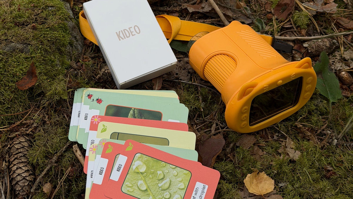 Microscope enfant Kideo jaune et ses cartes-missions posés sur la mousse, en forêt Image